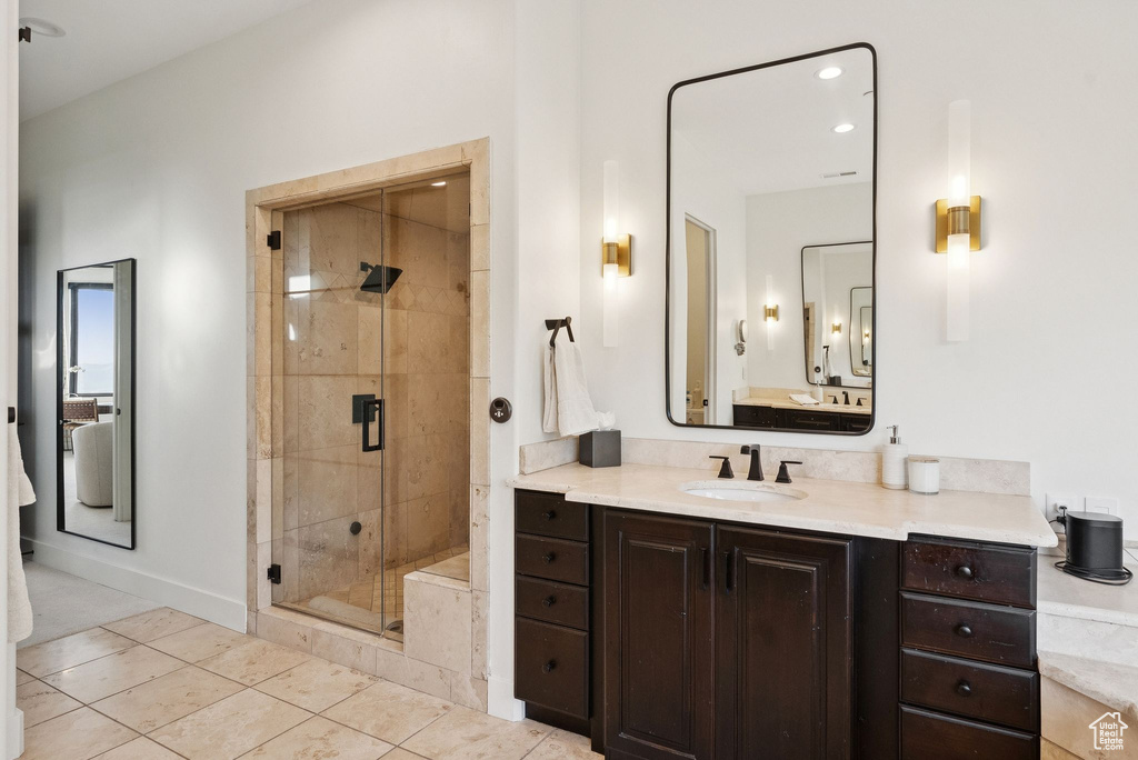Bathroom with vanity, a shower stall, and tile patterned flooring