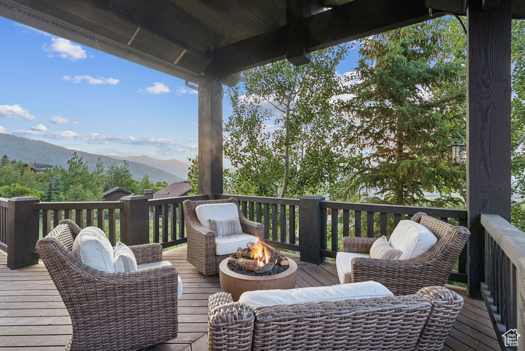 Deck featuring an outdoor fire pit and a mountain view