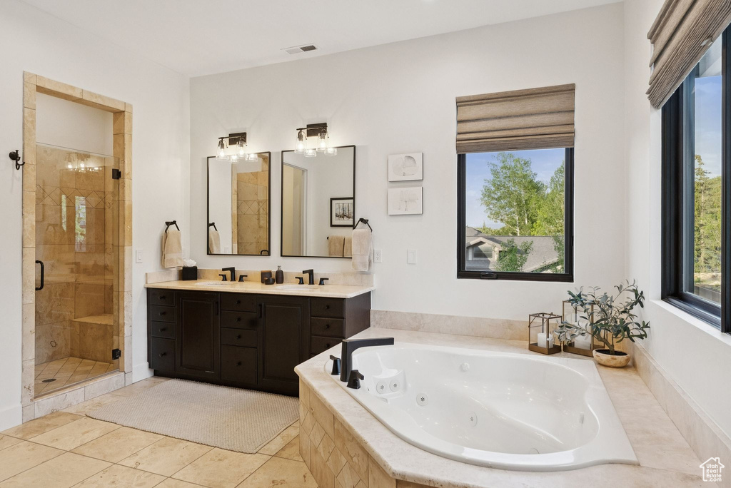 Bathroom with a shower stall, a tub with jets, double vanity, and tile patterned flooring