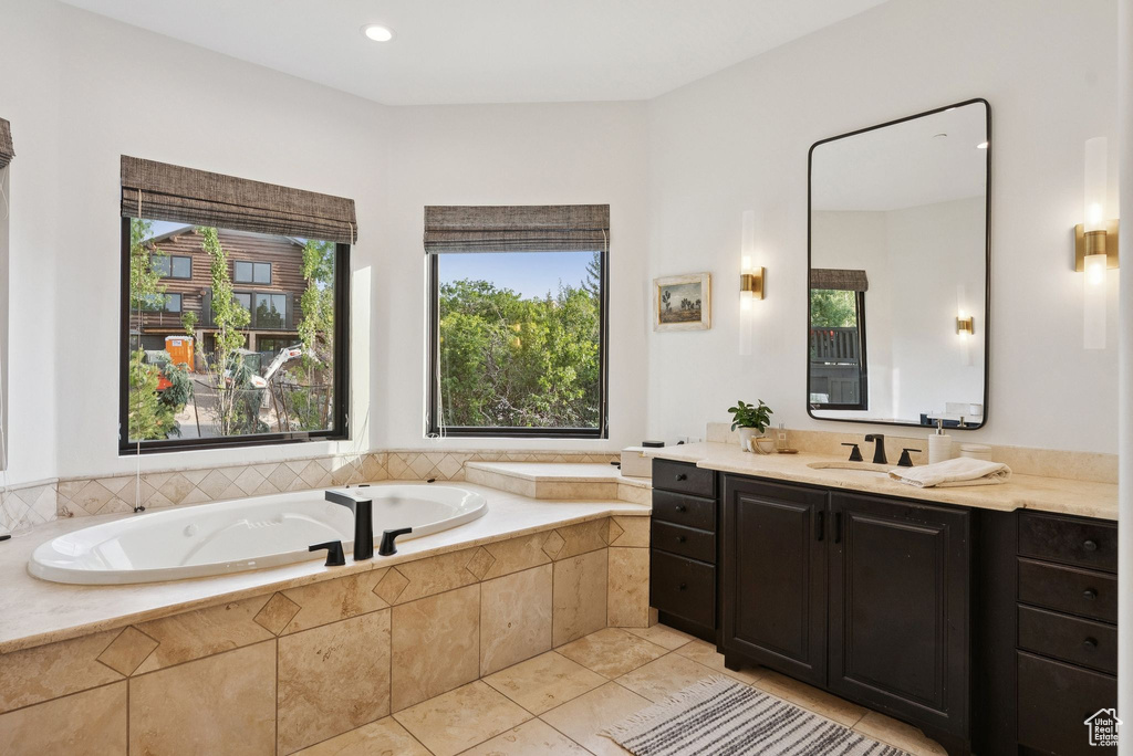 Bathroom featuring vanity, a bath, tile patterned floors, healthy amount of natural light, and recessed lighting