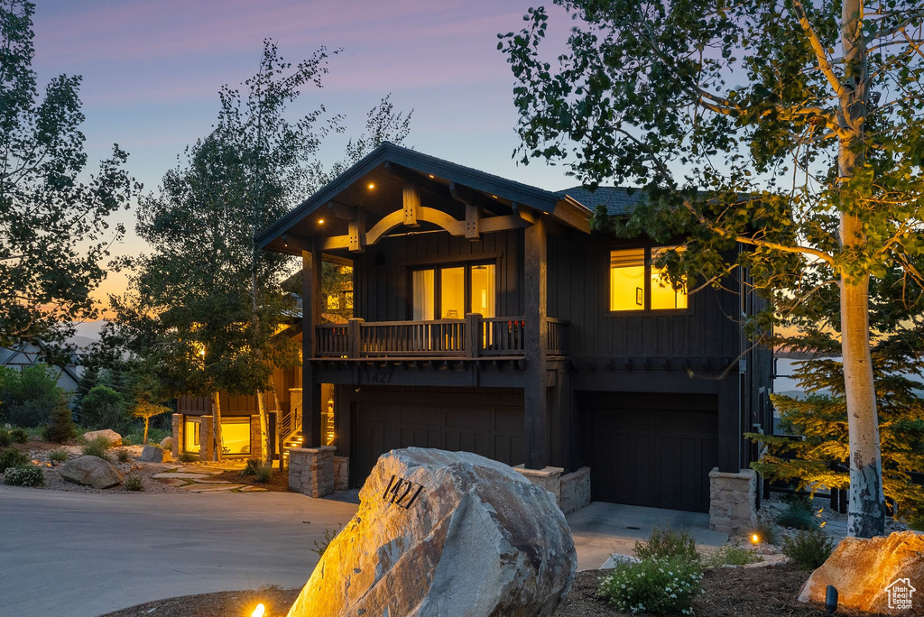 View of front facade with board and batten siding, a garage, and concrete driveway