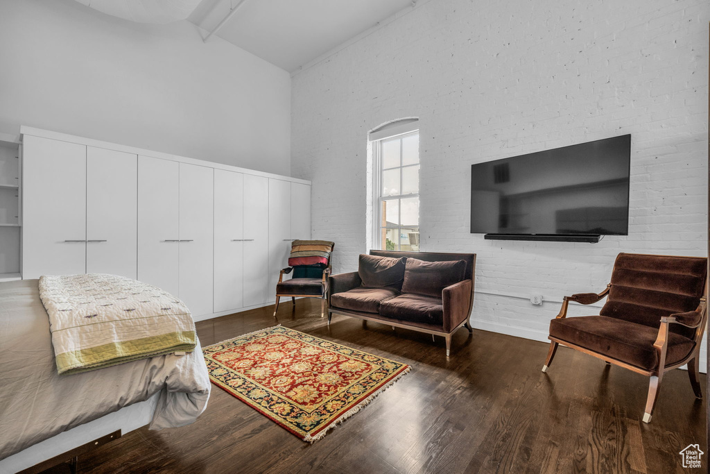 Bedroom with high vaulted ceiling, wood finished floors, and beam ceiling