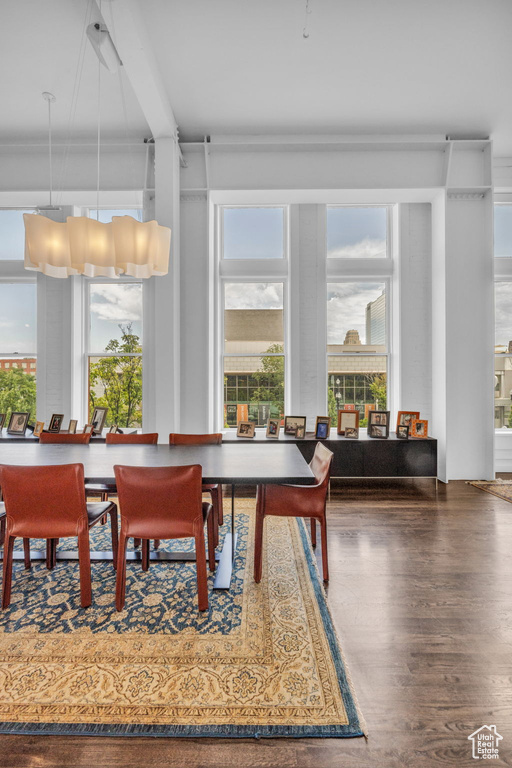 Dining area featuring healthy amount of natural light, wood finished floors, and beamed ceiling
