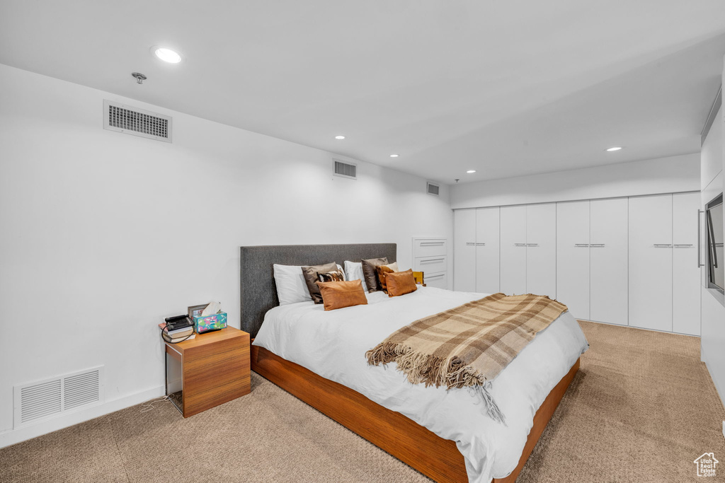 Bedroom with light carpet and recessed lighting