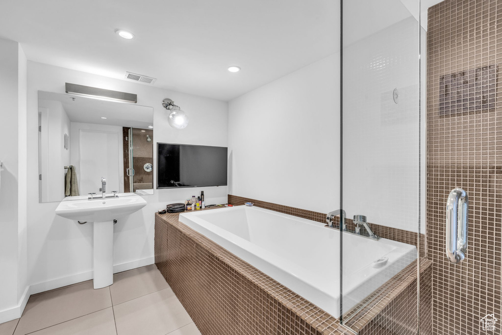 Bathroom with a garden tub, tile patterned floors, recessed lighting, and tiled shower