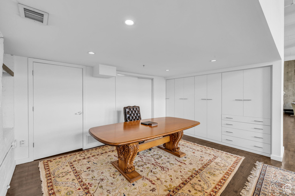 Office area featuring dark wood-style floors and recessed lighting