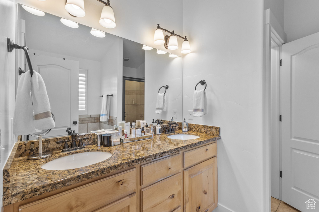Bathroom with double vanity, a stall shower, and tile patterned flooring