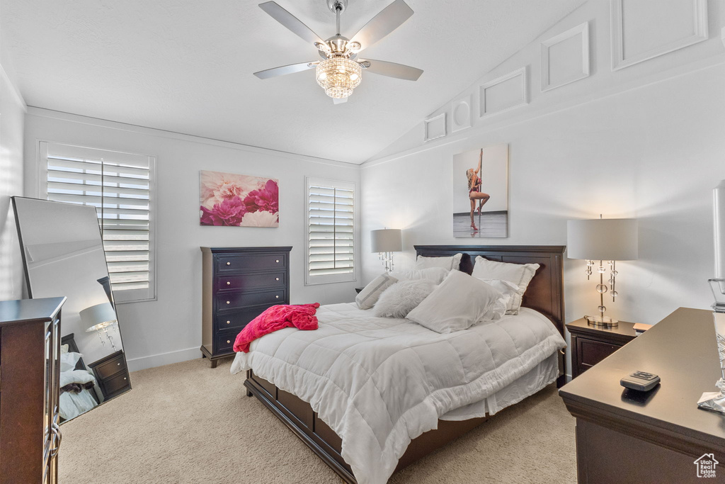 Bedroom featuring light colored carpet, lofted ceiling, and ceiling fan