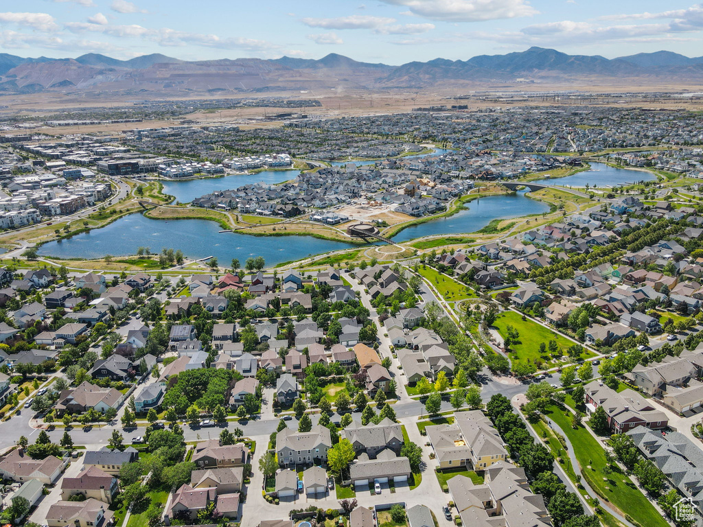 Aerial view of property and surrounding area featuring nearby suburban area and a water and mountain view