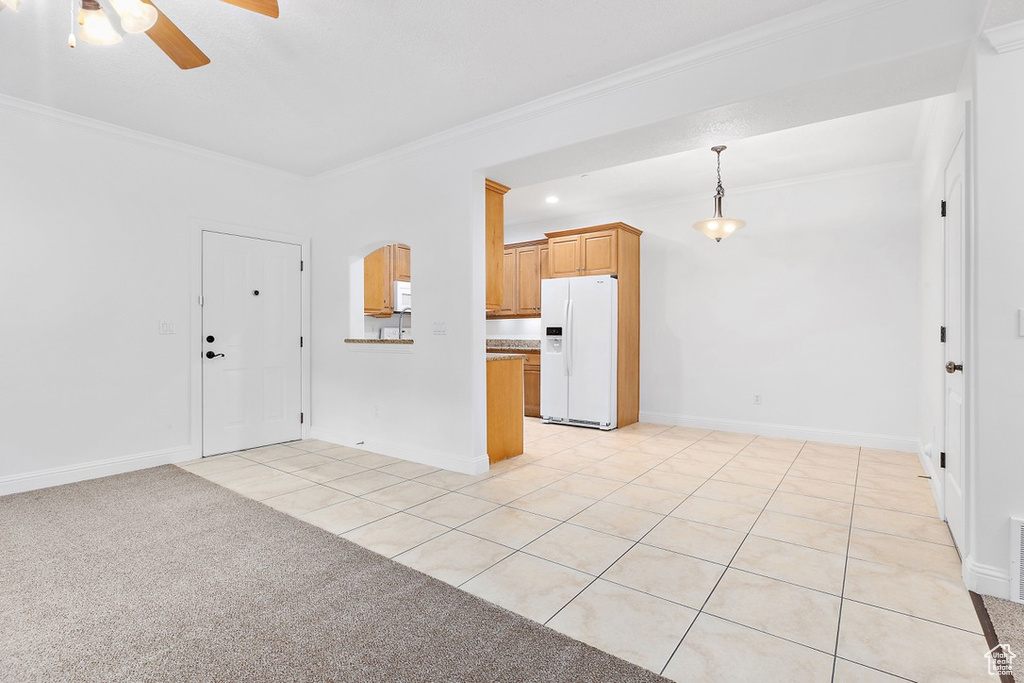 Unfurnished living room featuring ornamental molding, a ceiling fan, and light tile patterned flooring