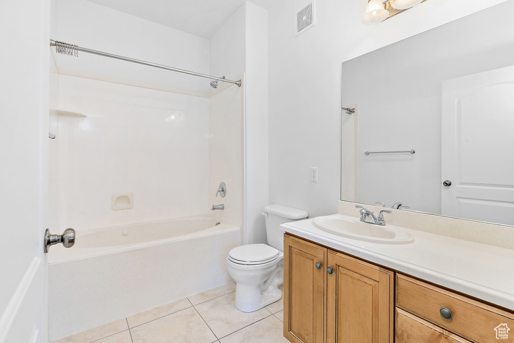 Bathroom with vanity, tile patterned floors, and washtub / shower combination