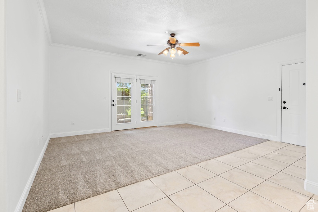Unfurnished room featuring light carpet, ceiling fan, and crown molding