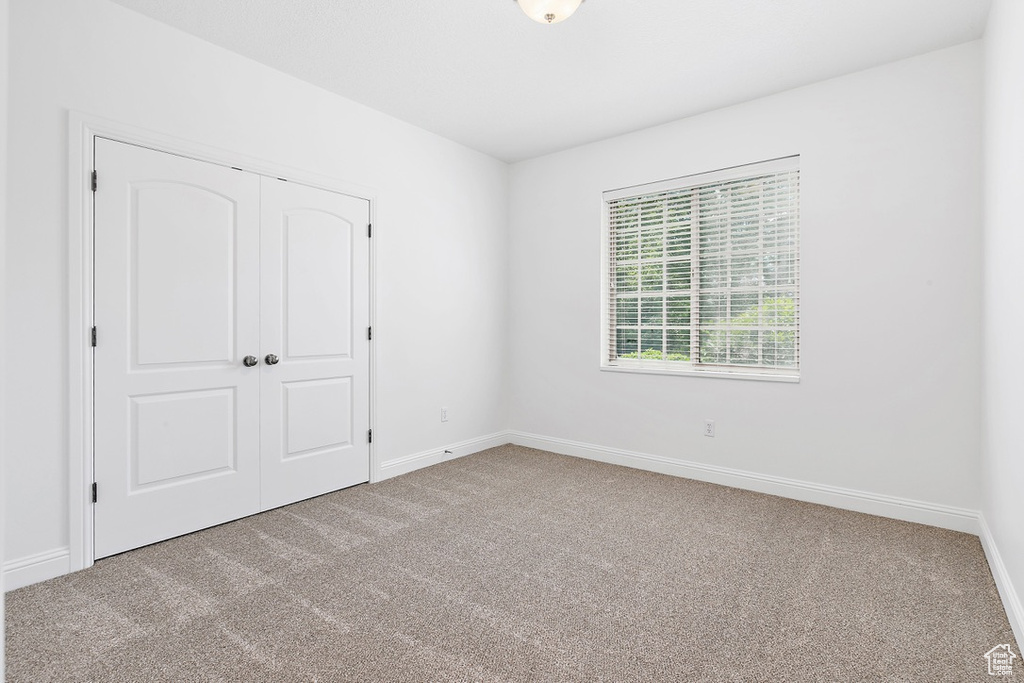 Unfurnished bedroom with carpet flooring and a closet
