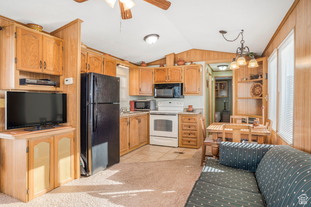 Kitchen featuring black appliances, vaulted ceiling, light tile patterned floors, ceiling fan, and light countertops