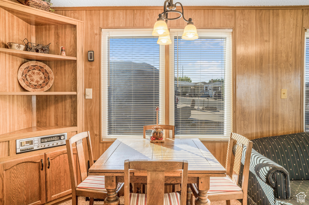 Dining space featuring wooden walls and built in shelves