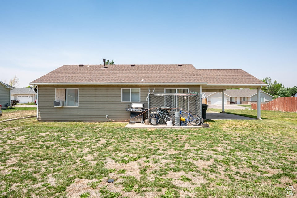Back of house with an attached carport and cooling unit