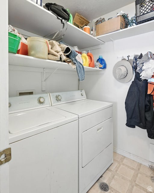 Laundry room with washing machine and dryer and light flooring