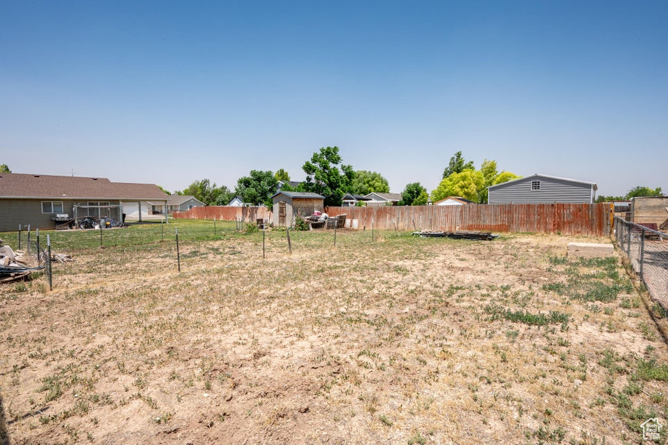 Fenced backyard featuring a storage shed