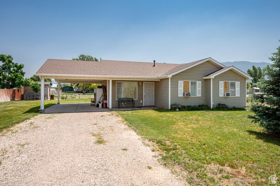 Single story home with driveway and an attached carport