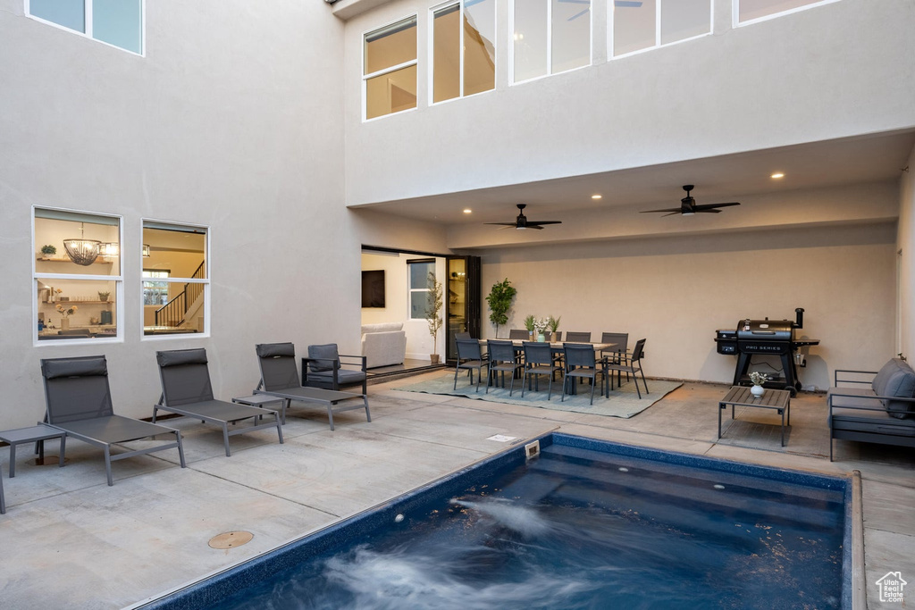View of swimming pool featuring a ceiling fan, a patio area, outdoor dining area, area for grilling, and a pool