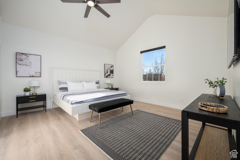 Bedroom featuring light wood-style flooring, high vaulted ceiling, and ceiling fan