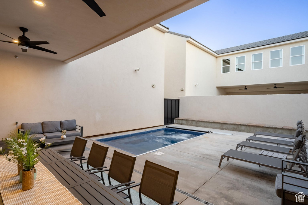 View of pool with a ceiling fan, a jacuzzi, an outdoor living space, and a patio