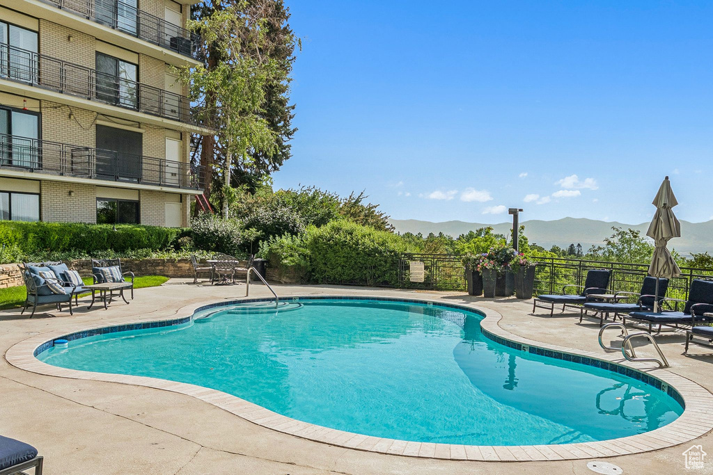 View of swimming pool featuring a patio and a mountain view