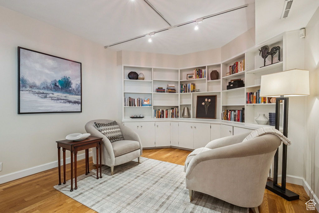 Sitting room featuring rail lighting and light wood finished floors