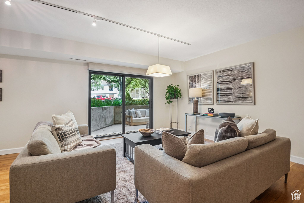 Living area with track lighting and light wood-style flooring