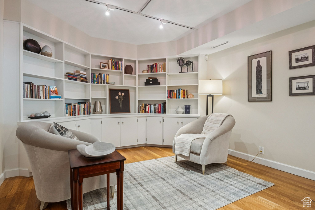 Sitting room featuring rail lighting and light wood-style floors