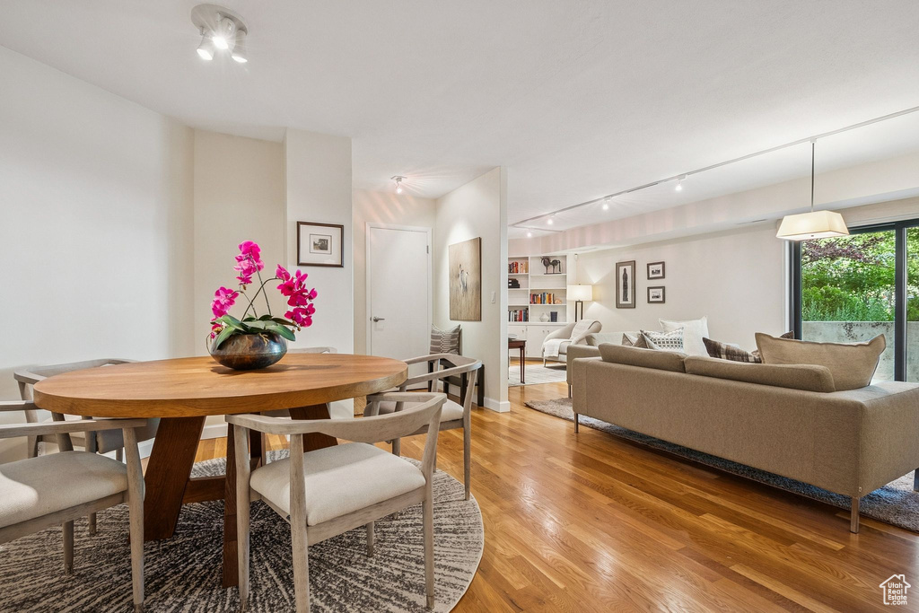 Dining room with light wood-style flooring and track lighting