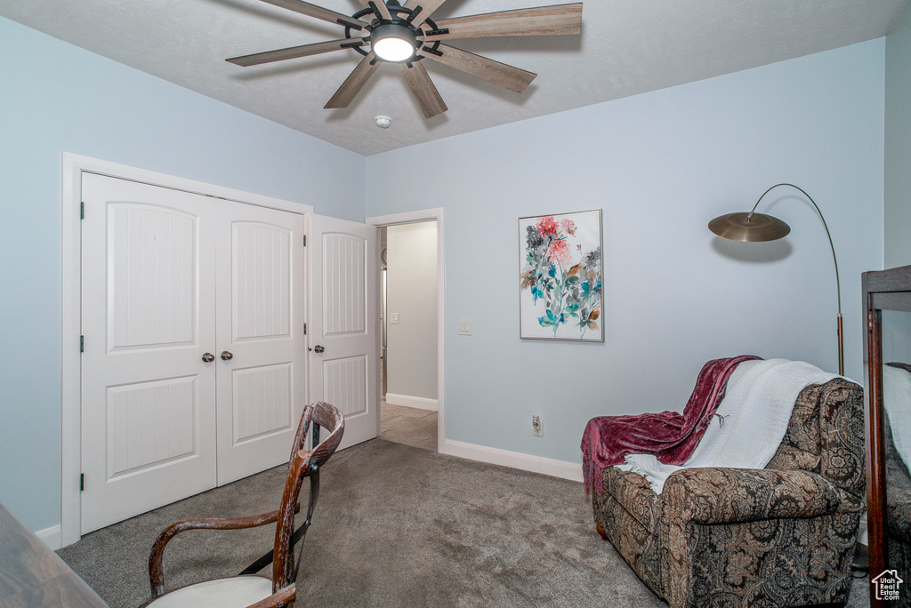 Carpeted office featuring a ceiling fan and baseboards