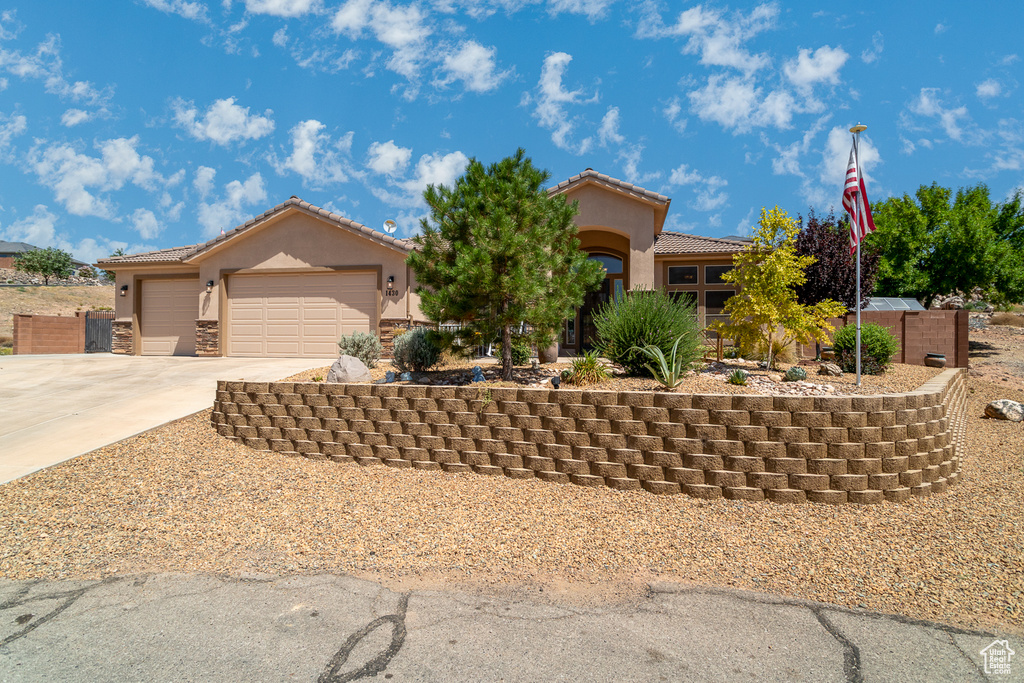 Mediterranean / spanish-style home featuring stucco siding, concrete driveway, a tiled roof, and an attached garage