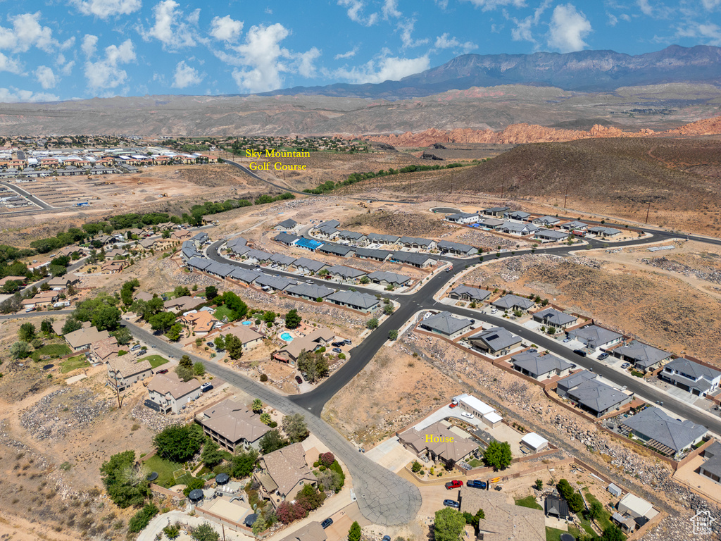 Aerial view of property and surrounding area with a mountainous background and nearby suburban area