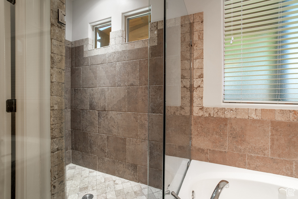 Bathroom with a shower stall and a bath