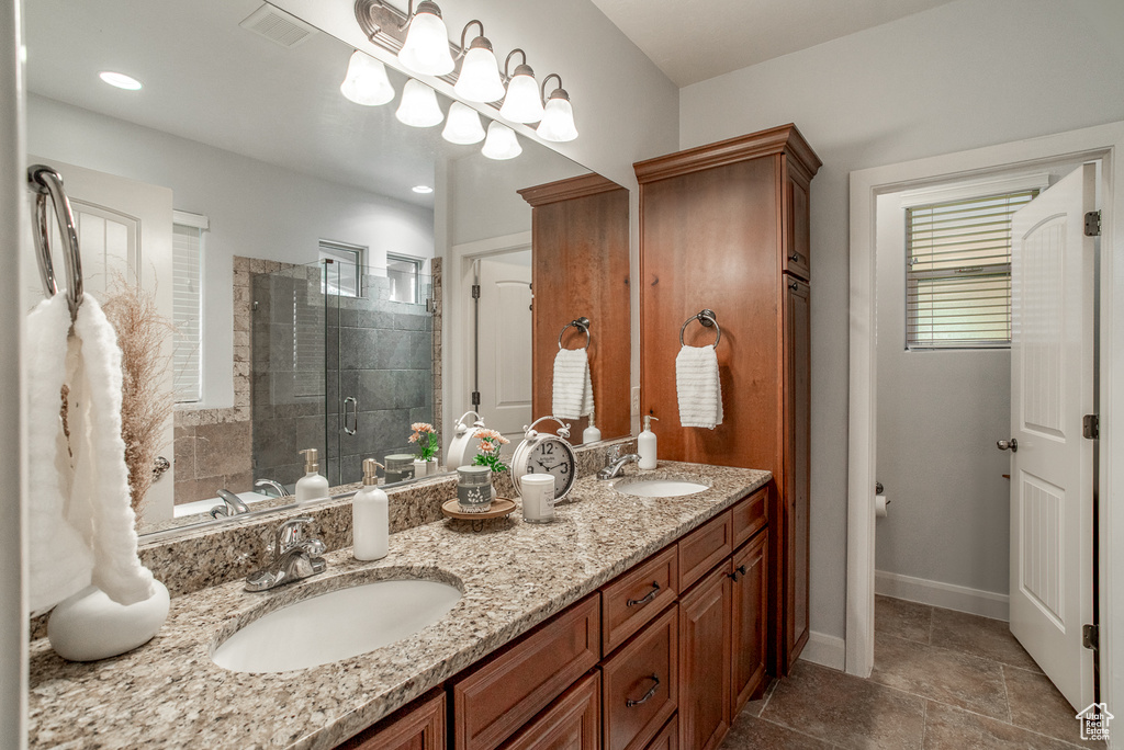 Bathroom with a shower stall, double vanity, and recessed lighting