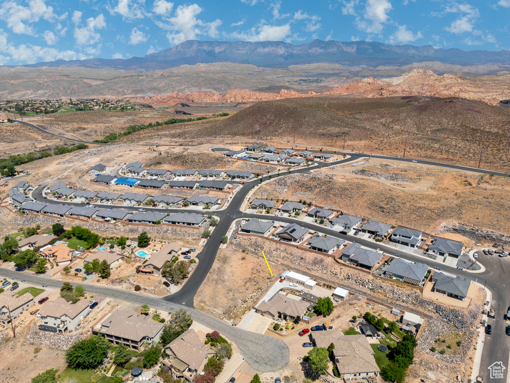 Aerial overview of property's location with a mountainous background and nearby suburban area