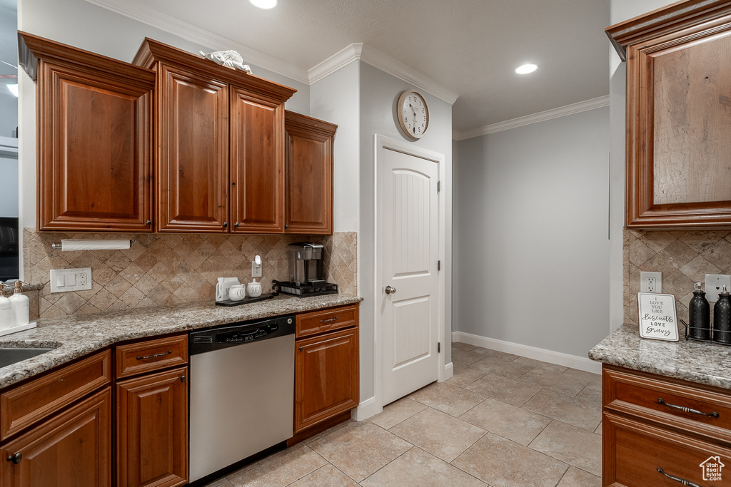Kitchen with dishwasher, crown molding, light stone countertops, backsplash, and brown cabinets