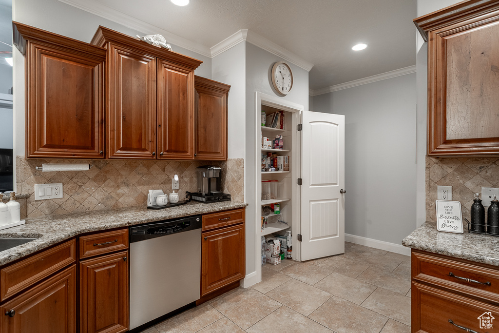 Kitchen featuring stainless steel dishwasher, crown molding, decorative backsplash, light stone countertops, and brown cabinets