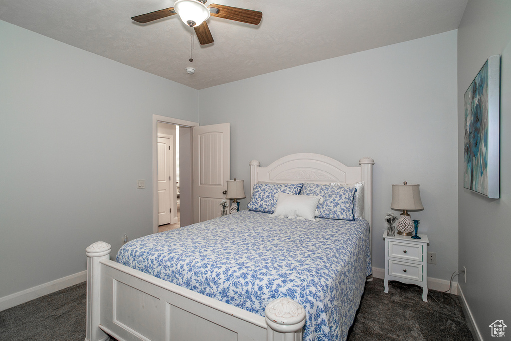 Bedroom with dark carpet and a ceiling fan