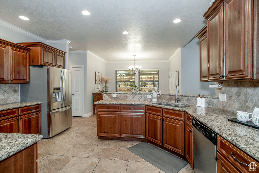 Kitchen with stainless steel appliances, a chandelier, decorative backsplash, a peninsula, and recessed lighting
