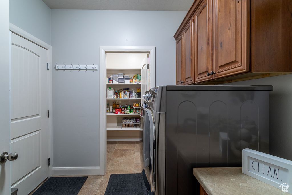 Washroom featuring cabinet space and separate washer and dryer