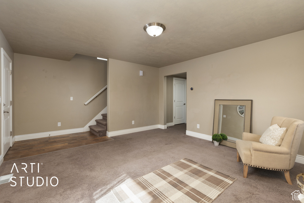 Living area with carpet flooring and stairway