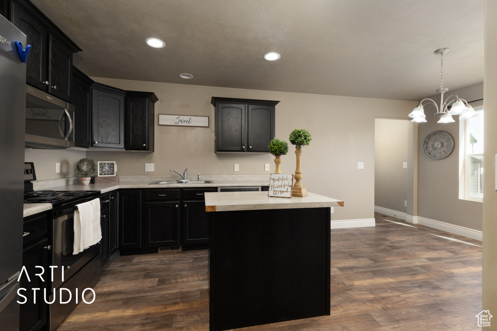 Kitchen with stainless steel microwave, electric range, light countertops, dark wood-style floors, and recessed lighting