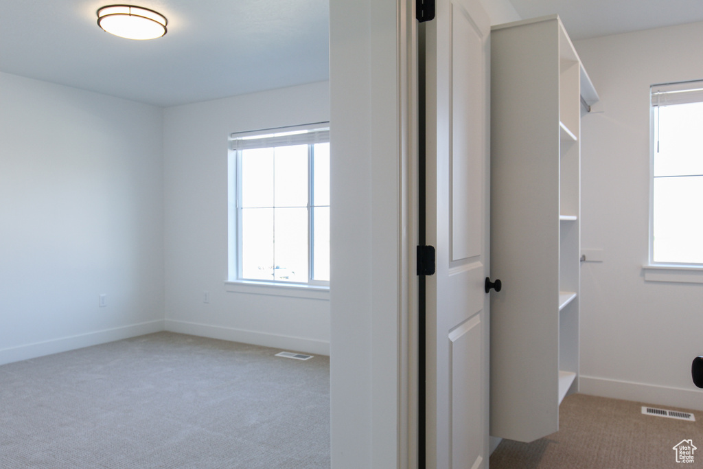 Hallway with carpet flooring and baseboards