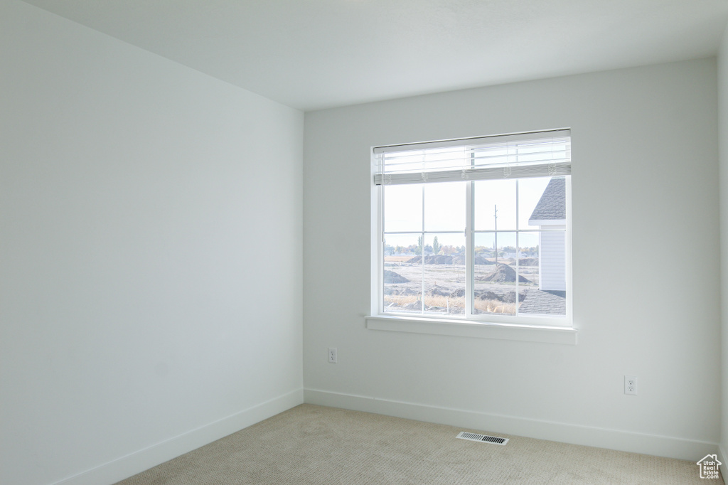 Spare room featuring healthy amount of natural light and carpet floors