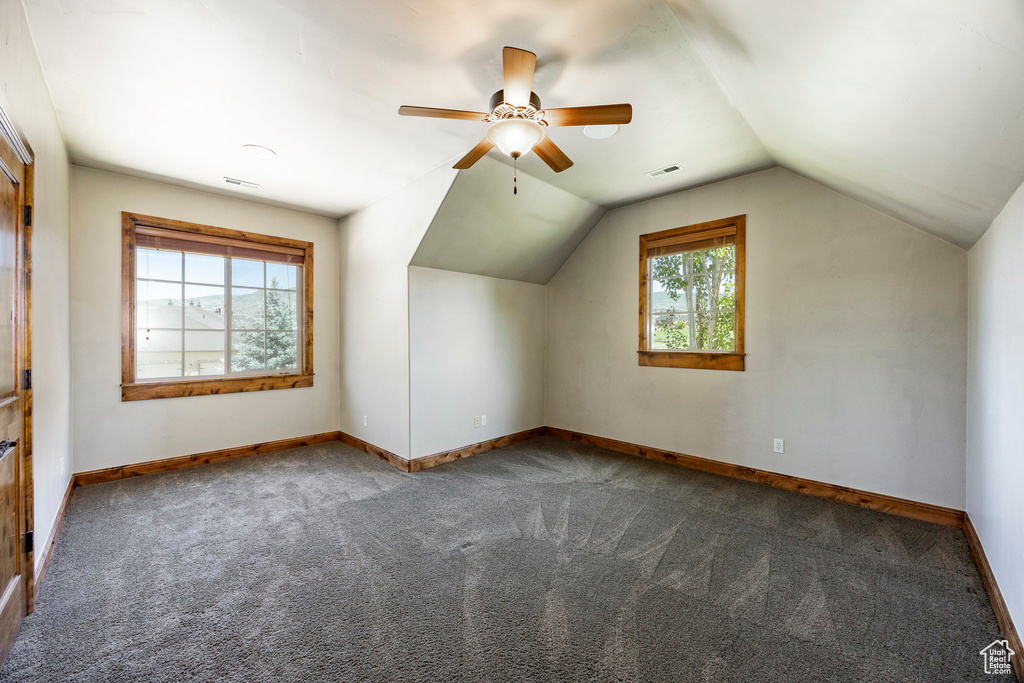 Additional living space with carpet, a ceiling fan, and vaulted ceiling