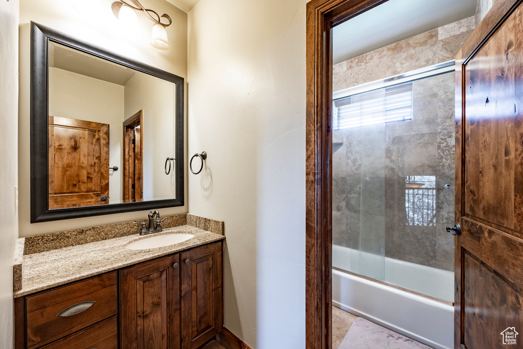 Full bathroom with vanity and combined bath / shower with glass door