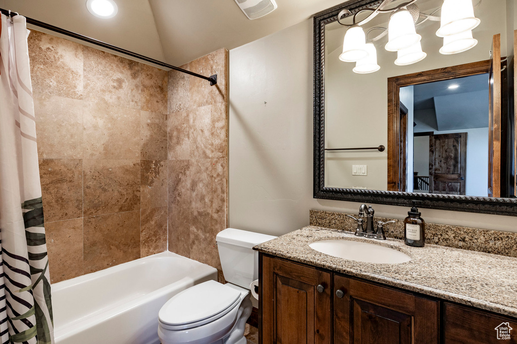Bathroom featuring shower / bath combo with shower curtain, vanity, and lofted ceiling