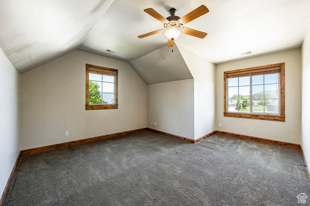 Additional living space featuring carpet, vaulted ceiling, and ceiling fan